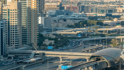 Futuristic building of Dubai metro and tram station and luxury skyscrapers behind timelapse