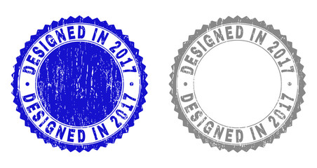 Grunge DESIGNED IN 2017 watermarks isolated on a white background. Rosette seals with grunge texture in blue and grey colors. Vector rubber stamp imprint of DESIGNED IN 2017 tag inside round rosette.