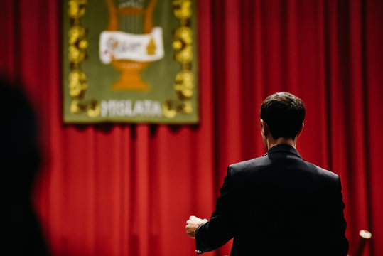 Orchestra Conductor From Behind Directing His Musicians During A Concert.