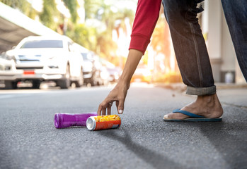 Photo of charity environment concept.  Hand's  man picking up Beverage cans on the street ground...