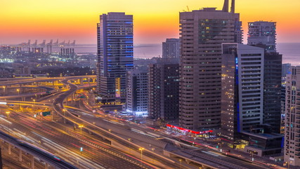 Fototapeta na wymiar Dubai marina with traffic on sheikh zayed road panorama day to night timelapse lights turn on.