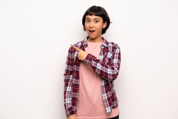 Young woman with short hair surprised and pointing side