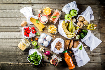 Zero waste shopping and sustanable lifestyle concept, various farm organic vegetables, grains, pasta, eggs and fruits in reusable packaging supermarket bags. copy space top view, banner