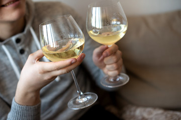 close up of hands with two white wine glasses