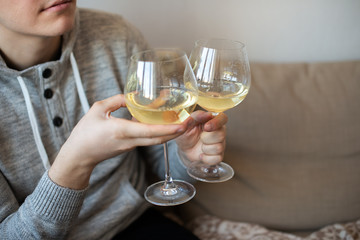 close up of hands with two white wine glasses