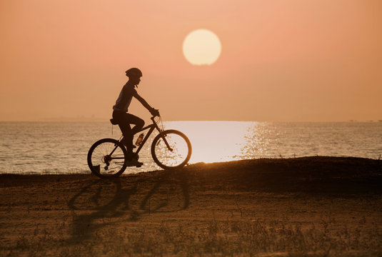 silhouette of cyclist on sunset or sunrise sky background © ittipol