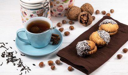 Cup of tea, stack of oatmeal cookies, tea maker on white wooden background Homemade bakery Healthy...