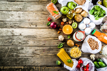 Zero waste shopping and sustanable lifestyle concept, various farm organic vegetables, grains, pasta, eggs and fruits in reusable packaging supermarket bags. copy space top view, banner