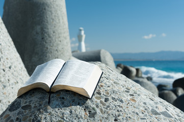 Beautiful landscape with open Bible in Psalm 119 with blue sky. Blurred background with white...
