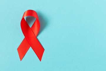 Red aids ribbon.  Isolated on blue background with empty space for text.