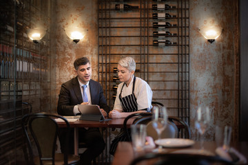 Chef and restaurant owner talking with financial advisor investor
