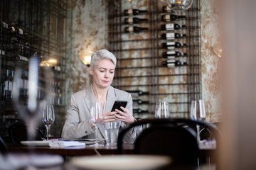 Businesswoman using smartphone in a restaurant