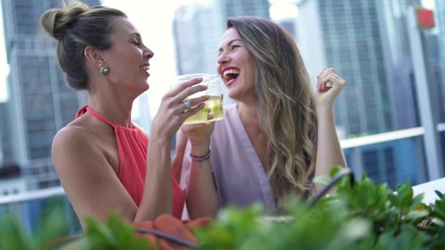 Slow motion of stunning young women partying on sophisticated rooftop bar in city