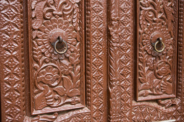 Carved brown doors with metal knocker