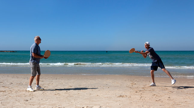 Men of different generations play beach tennis