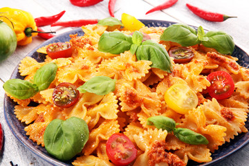 farfalle. Delicious creamy Italian penne pasta starter with pepper seasoning and fresh basil viewed from above on rustic