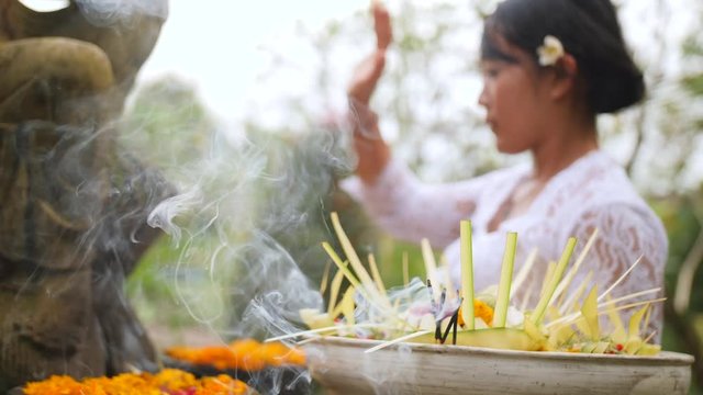 Woman Makes an Offering in a Hindu Temple. Traditional Balinese Spiritual Offering Process. 4K, Slowmotion.