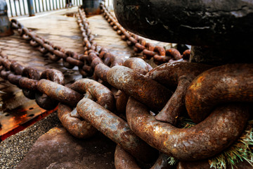Close up of old rusty chain, industrial port with chains, crane background out of focus, sunny day, industrial concept