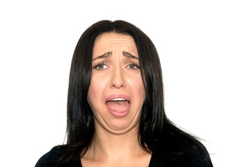 Close-up portrait of brunette girl is standing and looking at camera with disgust and anger. She is...