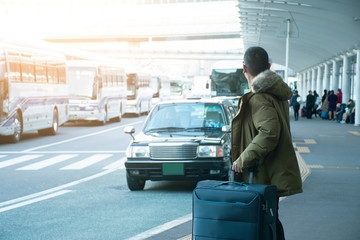 A man tourist is waiting taxi in front of Tokyo Airport in Japan.