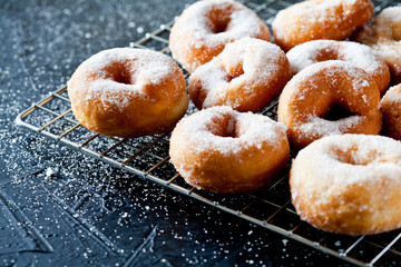 Few Donuts With Powdered Sugar On A Cooling Tray