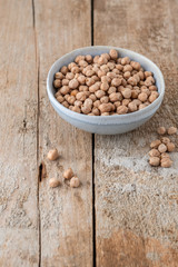 Schüssel mit getrocknete Kichererbsen auf einem alten Holzhintergrund