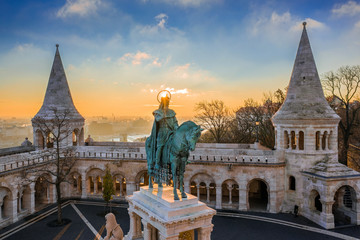 Naklejka premium Budapeszt, Węgry - Widok z lotu ptaka na wieże słynnego Baszty Rybackiej (Halaszbastya) z pomnikiem króla Stefana I o wschodzie słońca