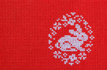 Easter rabbit embroidered on a red canvas.