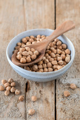 Schüssel mit getrocknete Kichererbsen auf einem alten Holzhintergrund