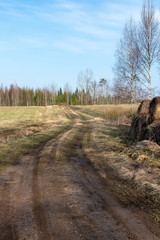 empty country gravel road with mud puddles and bumps