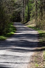 empty country gravel road with mud puddles and bumps