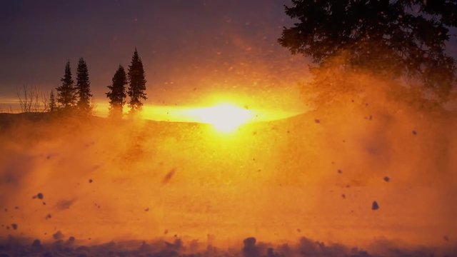 close-up of snowmobile tracks in slow motion.  backlight on the snow spray from the track. red sun and rays of light. stock video footage. Slow motion 