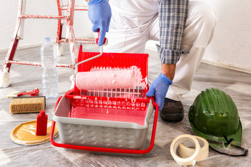 Professional house painter at work with the roller © francescomou