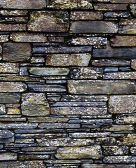 stone wall fragment, flat size stones of different sizes, thickness, width making a beautiful structure in different colors