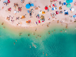 aerial view of sunny sandy beach with blue azure water