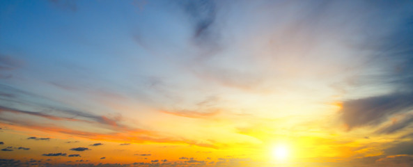 Naklejka na ściany i meble Cloudy sky and bright sunrise over the horizon. Wide photo.