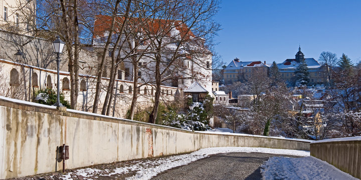Altenburg / Germany: View from the castle driveway to the outer gatehouse on the left and the Evangelical-Lutheran Magdalenen-Stift in the back on a beautiful winter day