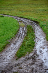 Fototapeta na wymiar empty country gravel road with mud puddles and bumps