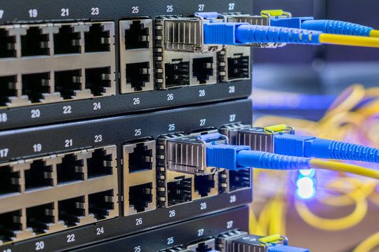 Fiber-optic wires are connected to the sfp module of the Internet switchboard. Server equipment of the telecommunications provider. The concept of modern high-speed communication.