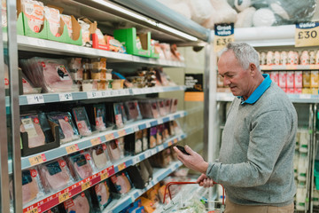 Senior Man Using Smart Phone for Shopping List