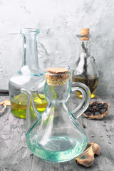 oil jugs with olive oil and black garlic in rustic gray setting