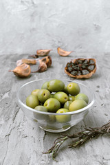 glass bowls with green and black olives, on gray rustic stage