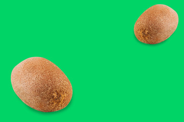 Pair of fresh whole shaggy kiwis on green background with copy space for your text