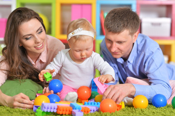 Portrait of happy parents playing with daughter