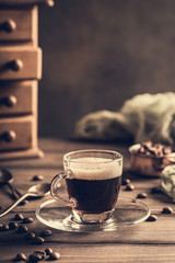 Coffee cup on old wooden background with copy space. Retro style toned dark photography.