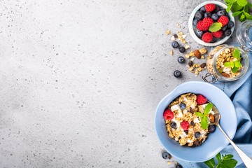 Healthy food background with homemade oatmeal granola or muesli with yogurt and fresh berries for healthy morning breakfast, top view, copy space.