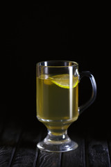 Low key photo of glass of lemon tea on wooden table