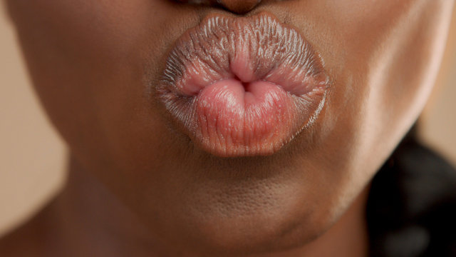 closeup of mixed race black woman mouth sending kiss. Kissing camera