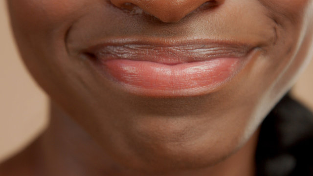 closeup of mixed race black woman mouth smiling without show tooth