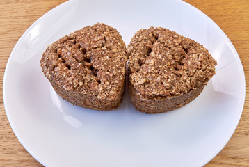 Two slices of fresh homemade bread made from wheat and rye on a white plate